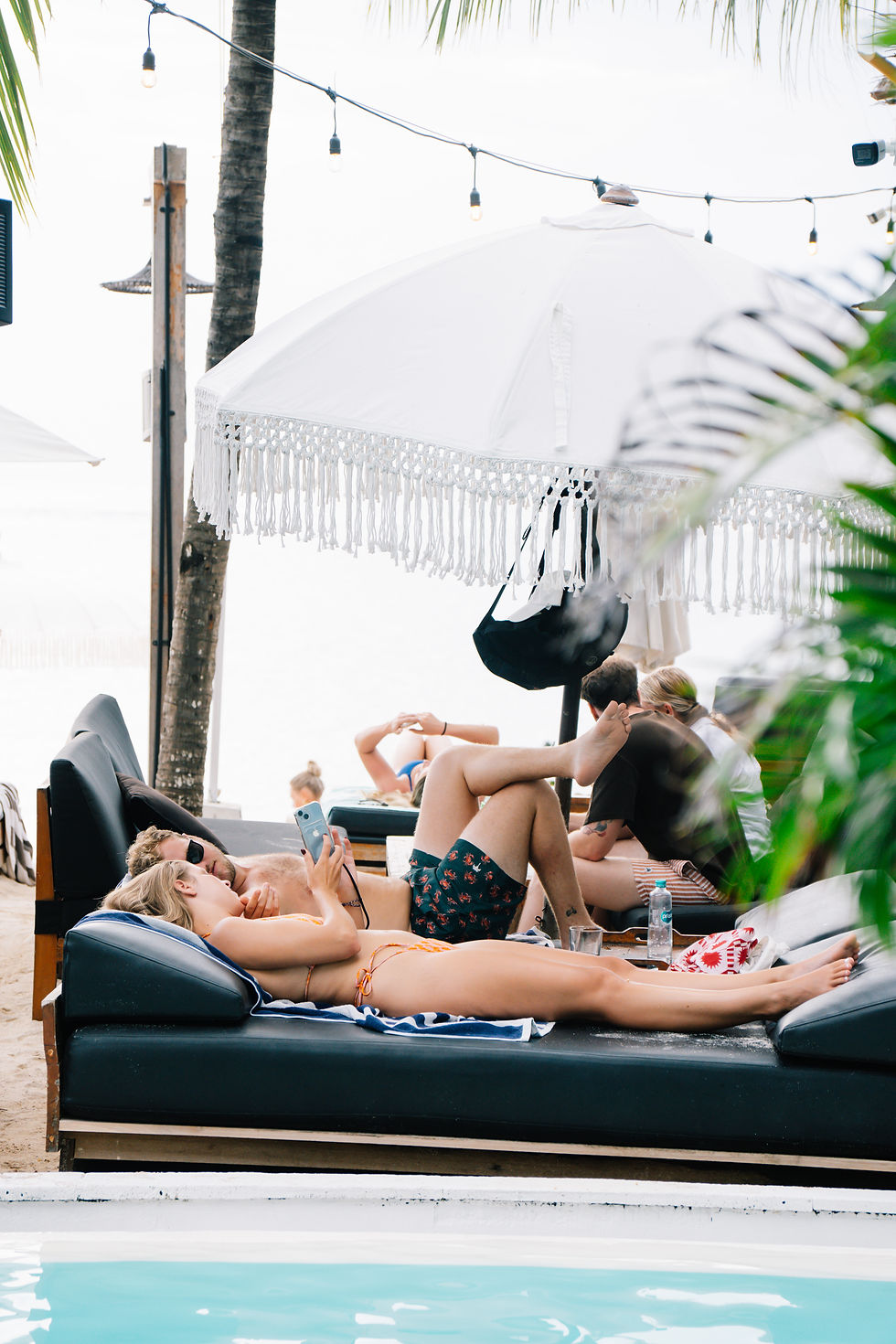 Couple relaxing on a poolside daybed at Ohana's