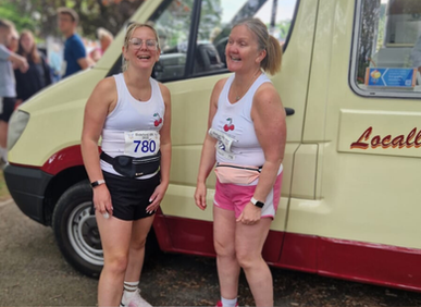 A picture of two staff members in TNCT vests smiling before their Bideford 10k run. 
