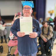 Person holding their certificate and smiling