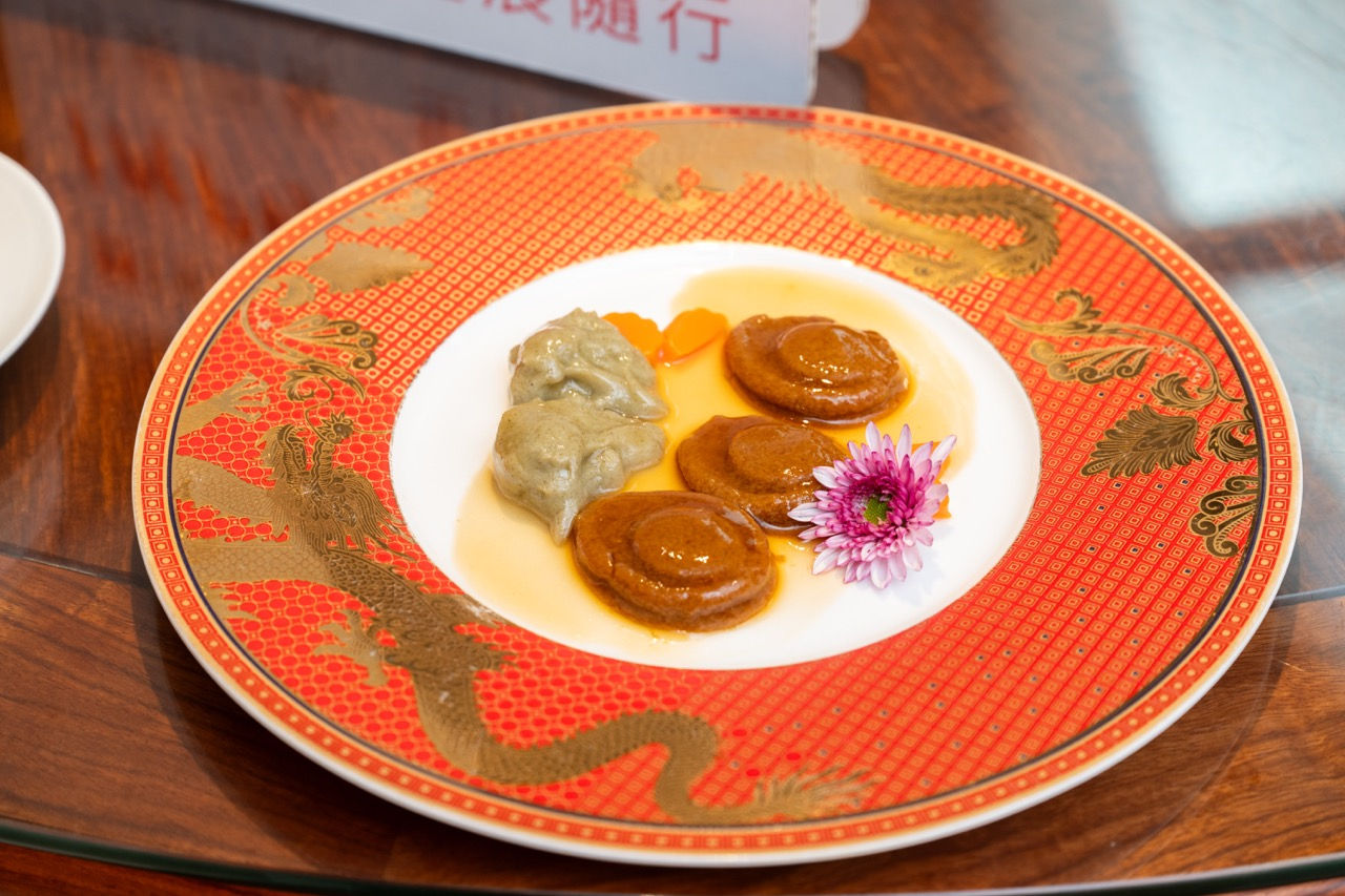 鍾菜館吞嚥友善軟餐「古法扣八頭鮑魚」擺盤特寫，配上精緻紅色龍紋餐盤。