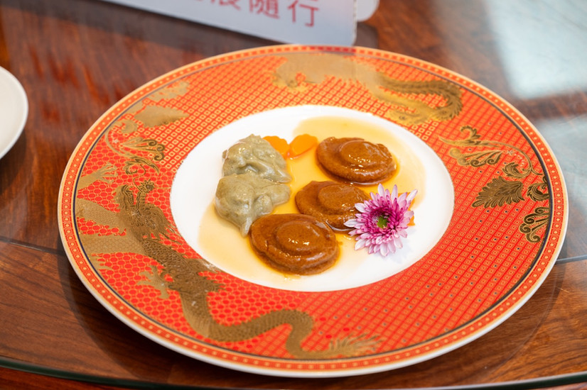鍾菜館吞嚥友善軟餐「古法扣八頭鮑魚」擺盤特寫，配上精緻紅色龍紋餐盤。