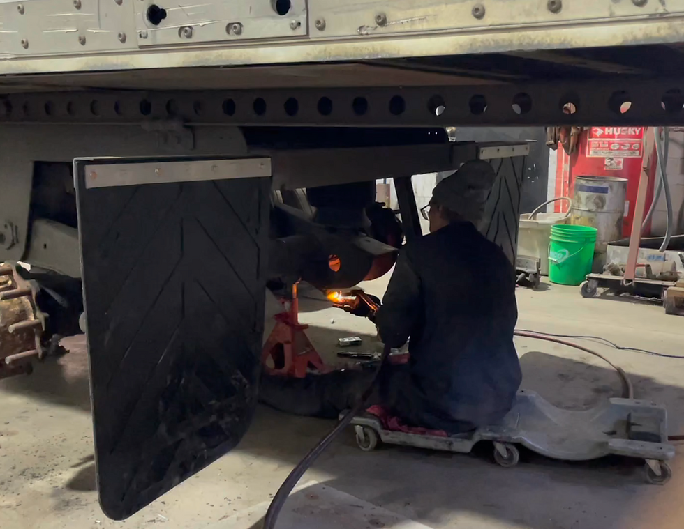A technician performing a break service on a semi trcks trailer.