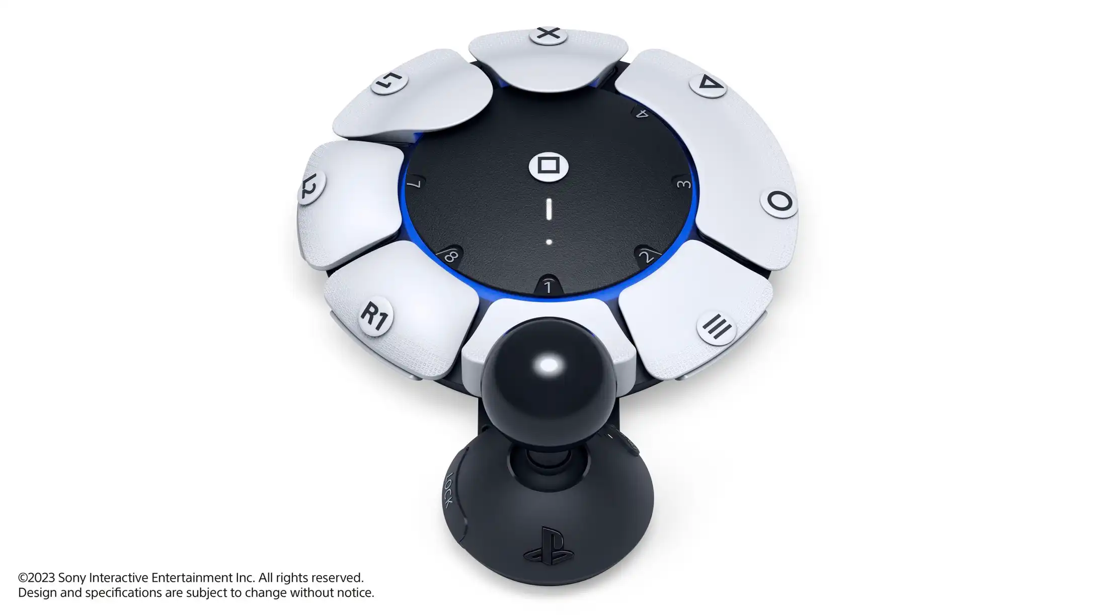 Image of the PlayStation Access controller, which is a circular device with multiple buttons around it of various shapes with labels. There is a joystick with a large ball attachment connected to the controller.