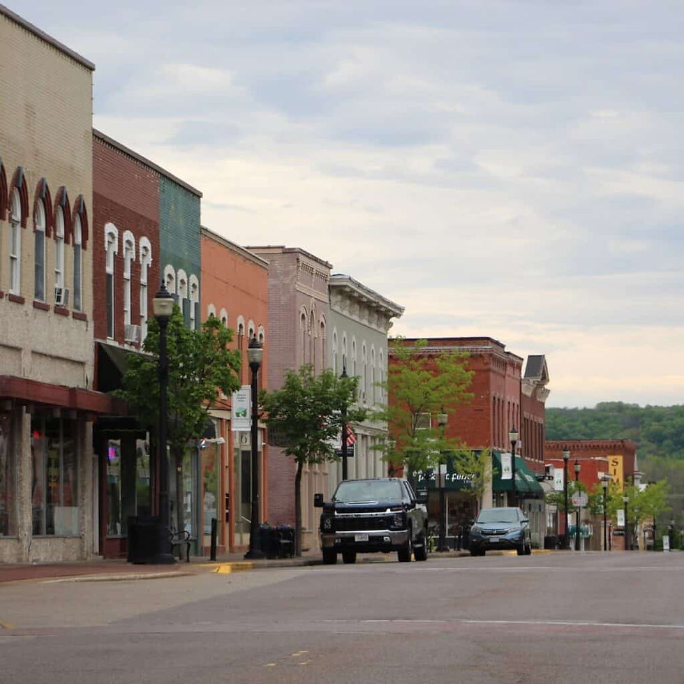 High angle view of a small town surrounded by rolling hills and forests in the Driftless Region