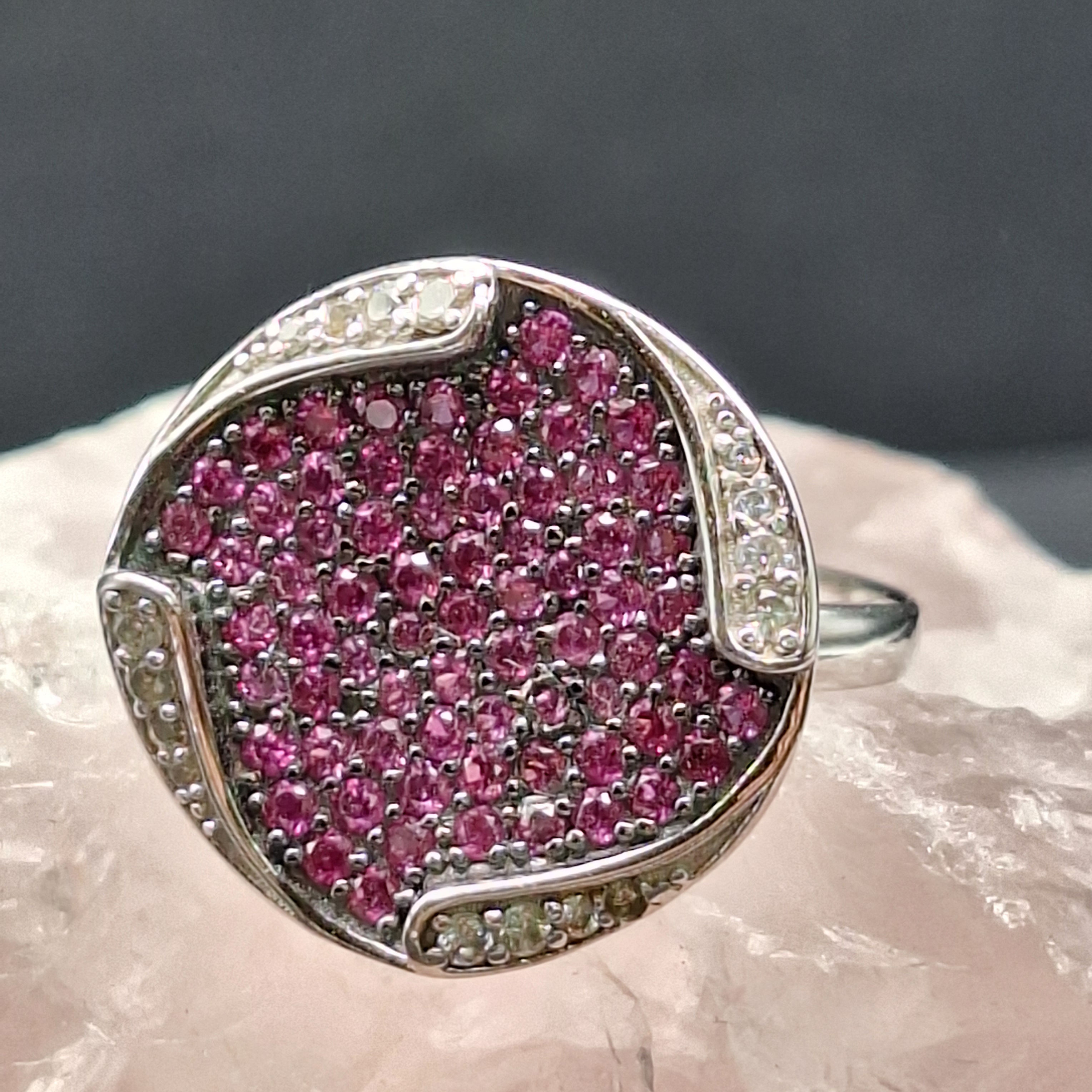 circular collection of rubies surrounded by white sapphires set in silver