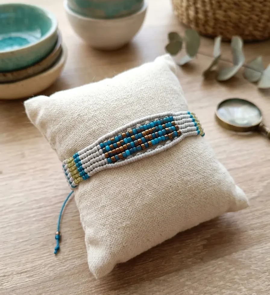 bracelet mosaïque bleu et doré fait artisanalement présenté sur un coussin en lin