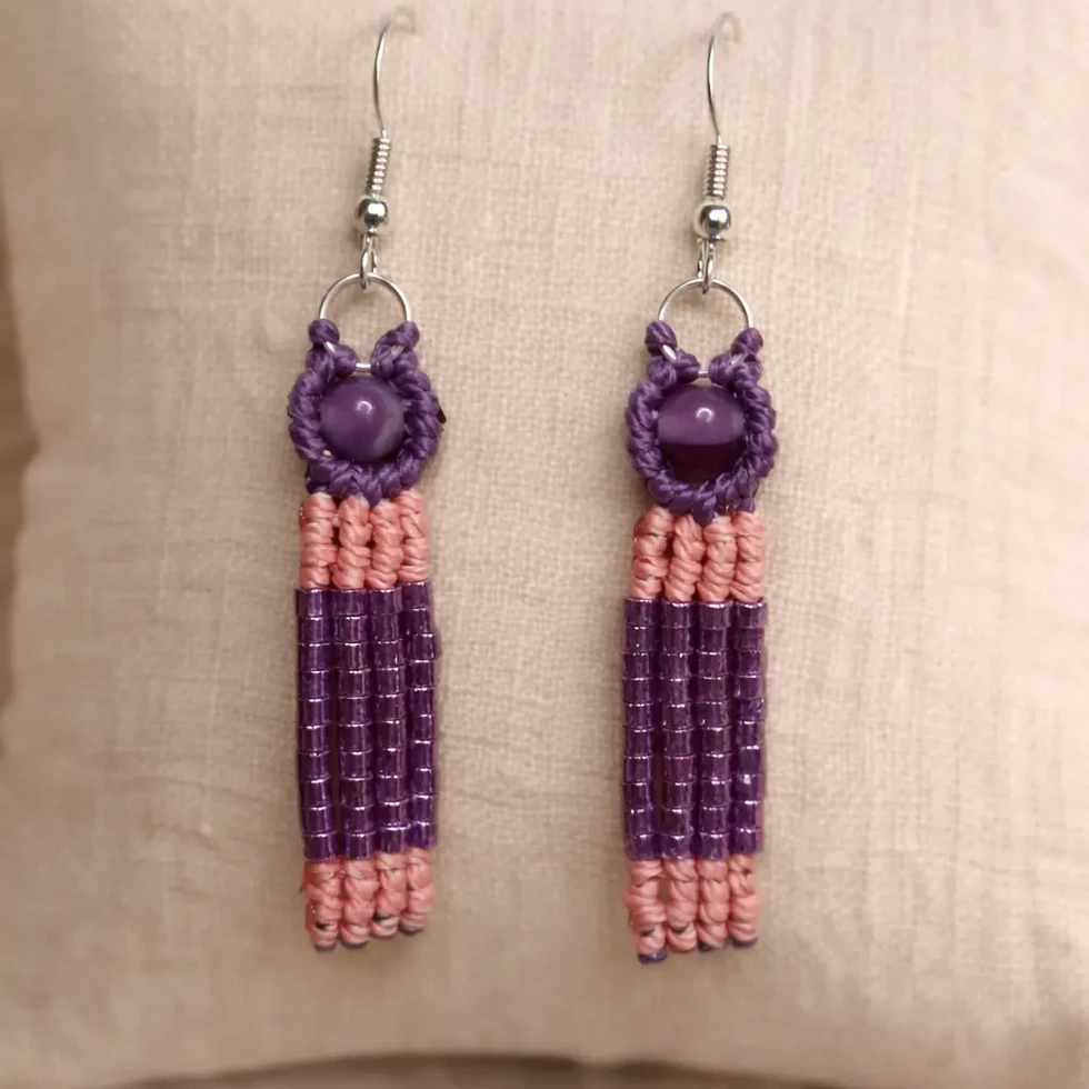 boucles d'oreilles pendantes faites main, avec des franges en perles de rocaille violettes et roses sur un coussin