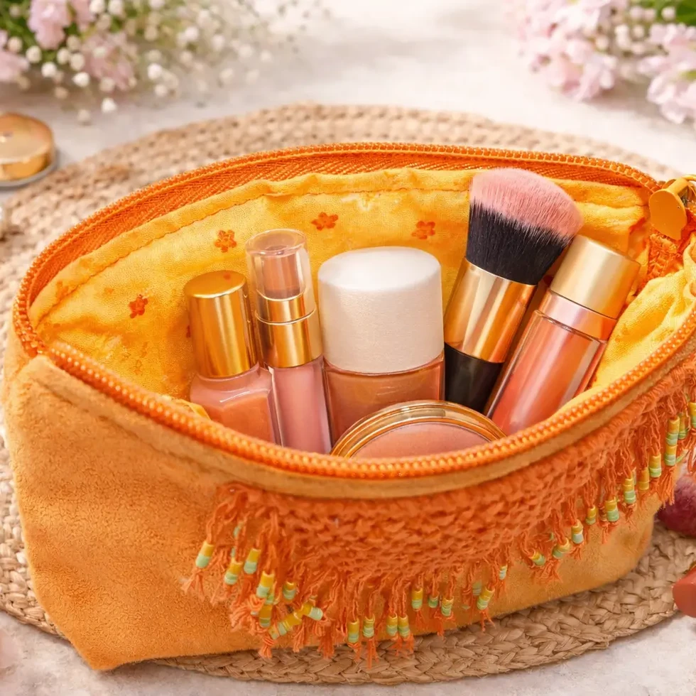 Intérieur de la pochette Solara ouverte, remplie de rouge à lèvres, de vernis et d'un pinceau.