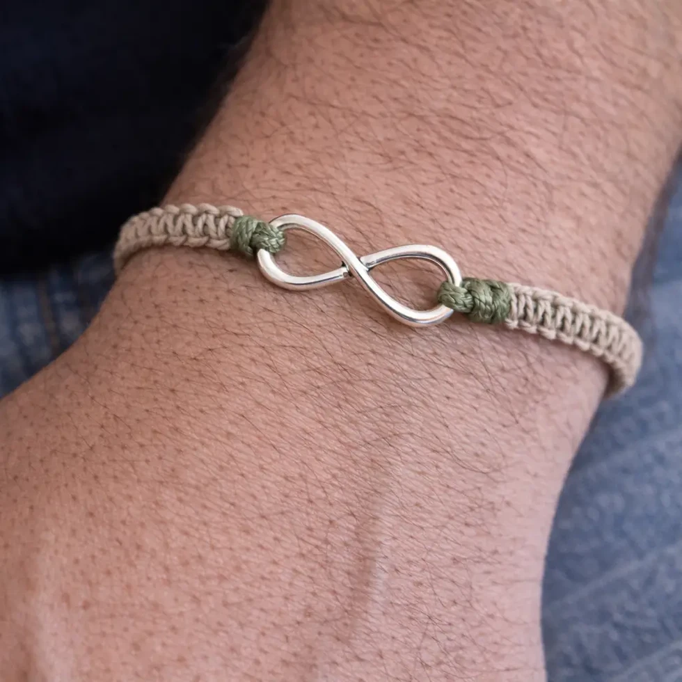 Bracelet infini macramé beige et vert kaki Maquis porté au poignet style nature.