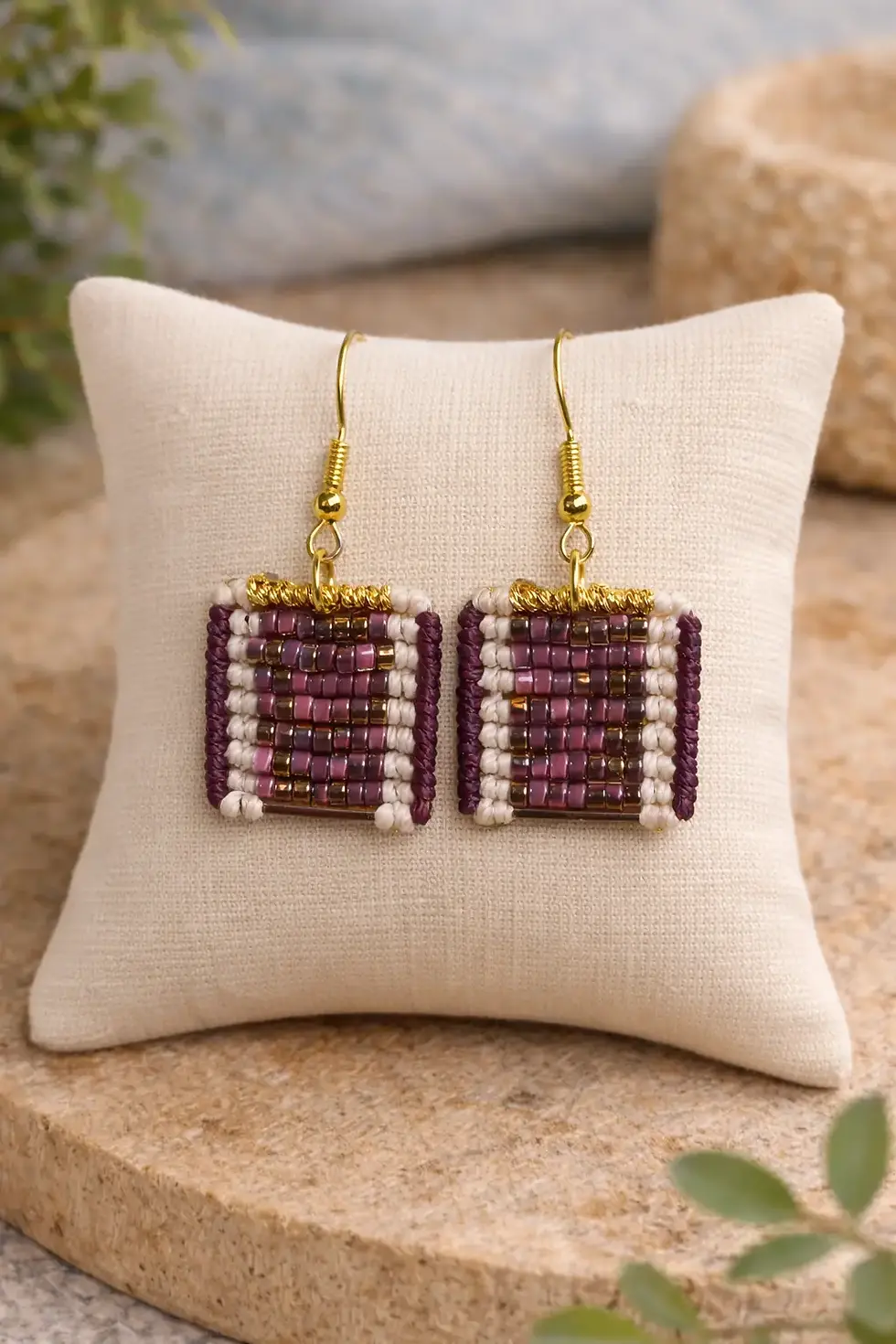boucles d'oreilles tessare tissées macramé avec une mosaïque de perle bordeaux, doré sur un coussin