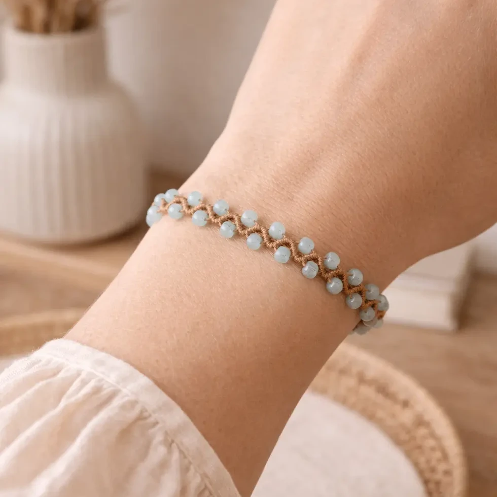 bracelet bohème en macramé sable avec perles œil de chat bleu clair – modèle Cattie au poignet