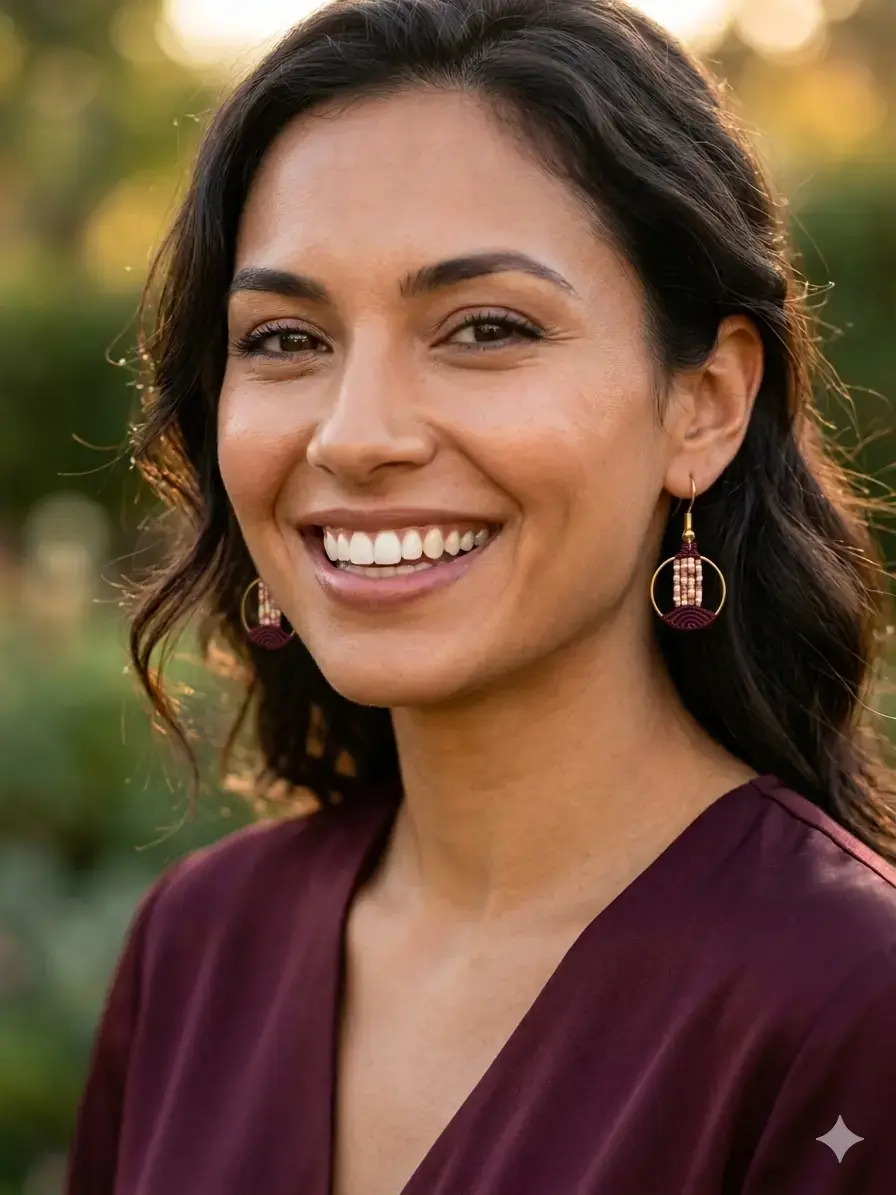 boucles d'oreilles lyren bordeaux en macramé artisanale portées par une jeune femme souriante