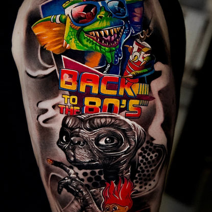 Buntes 80er-Style-Comic-Realism-Tattoo mit Schriftzug und Charakteren, tätowiert bei Dado Artist Collective in Arbon und Luzern.
