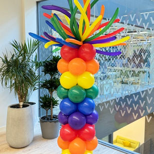 Bright rainbow balloon column for pride month with fluffy top balloons