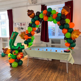 Balloon arch for kid's birthday cake table. It was delivered to the party by a Confetti Party balloon artist.