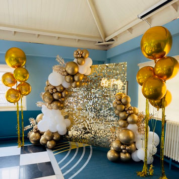 Gold and white colours balloons with a gold shimmer wall for an amazing Gatsby party