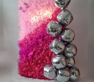 A bold pink backdrop with swirls, made from organza, used for as photo zone for the parties, created and installed by Confetti Party, party decorators in Guildford