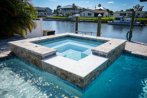 Luxury hot tub with cool blue water near waterfront by Trinity Pools