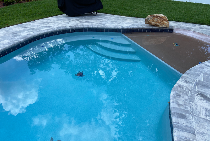 Zero-entry pool and stone pool deck designed and built by Trinity Pools