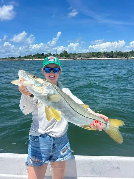woman holding large silver and yellow fish