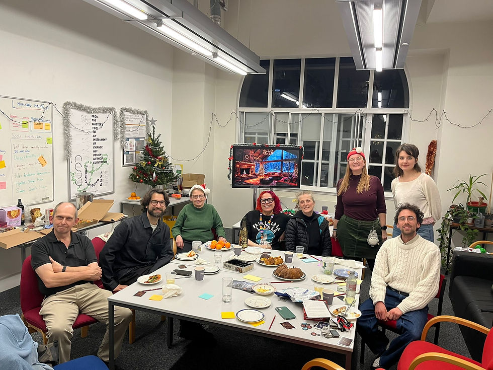 HCID Members sitting and standing around a table in a Christmassy, decorated HCID kitchen