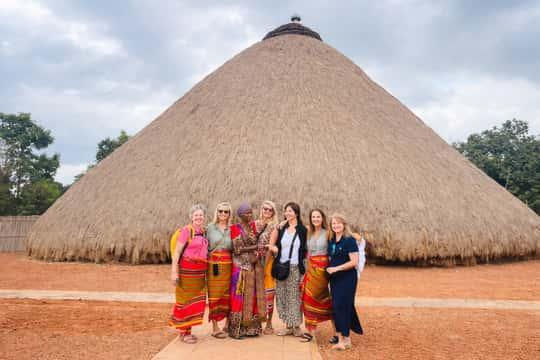 Group on Cultural Experience Tours by a large thatched hut.