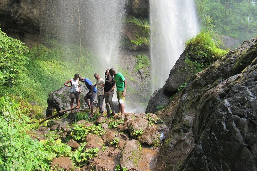 A group of hikers standing near the base of Sipi Falls.
