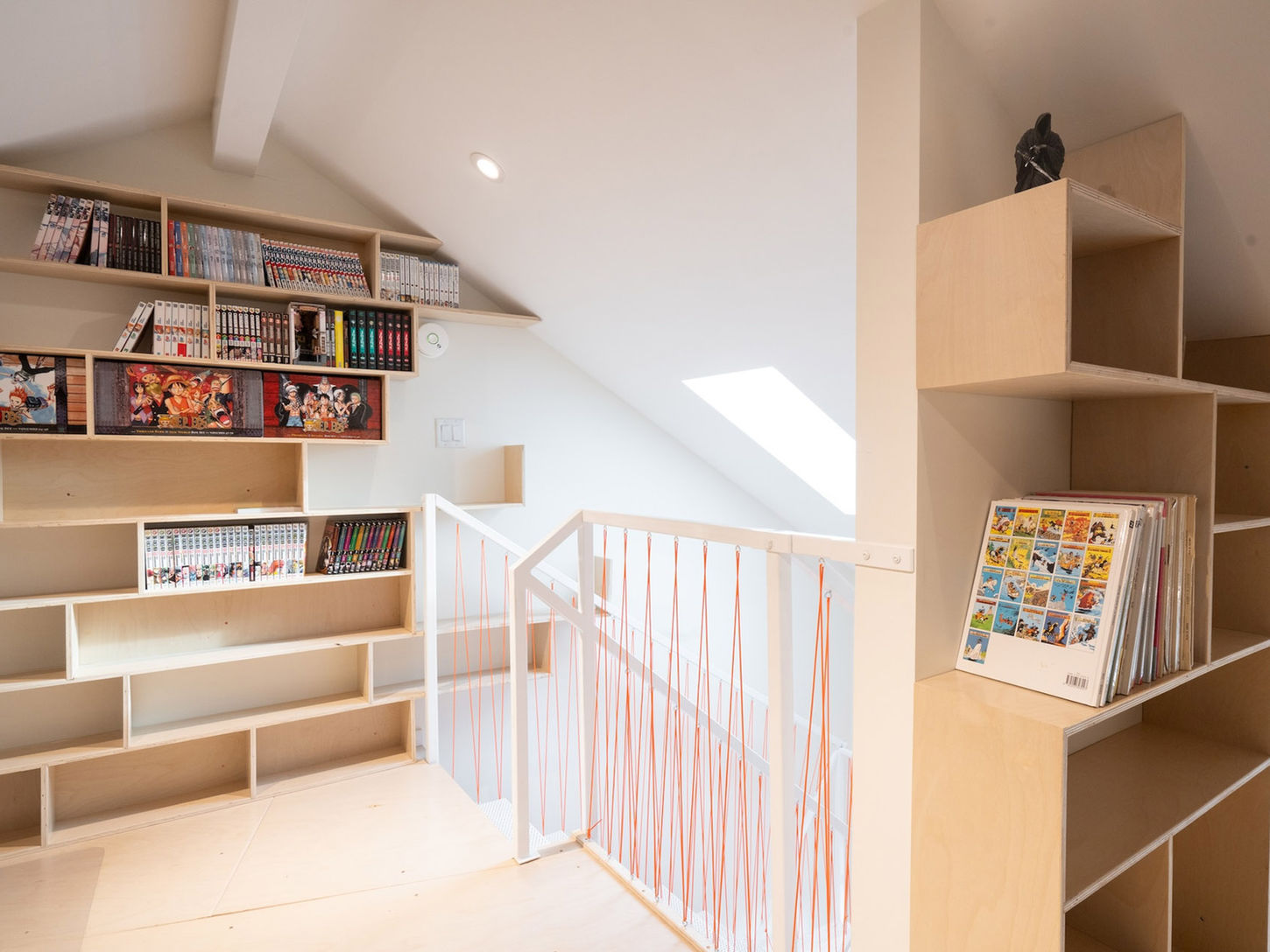 Attic storage area with open shelving, books, and decor, emphasizing clean lines and a functional layout