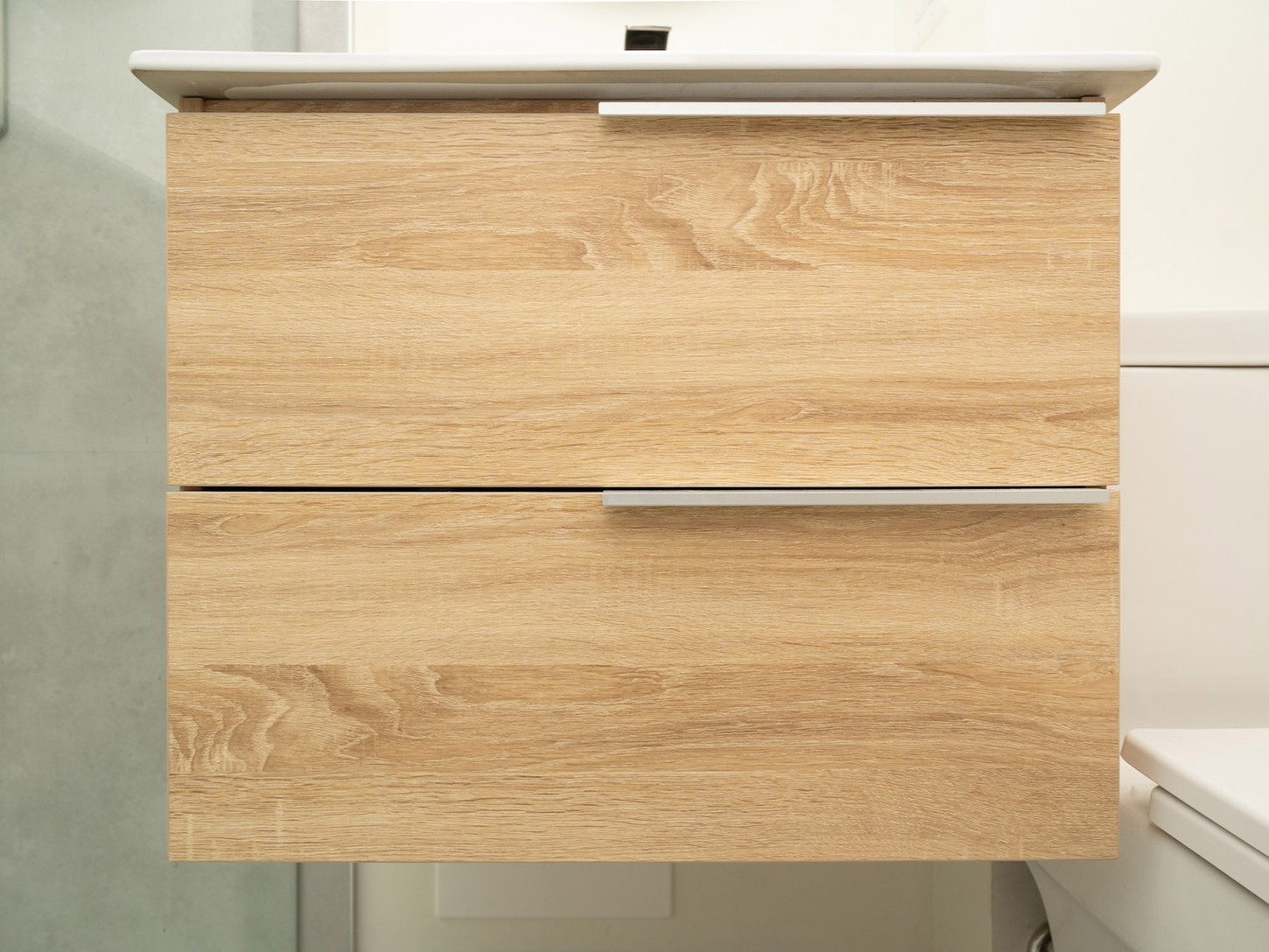Close-up of a modern floating wooden vanity with clean lines and a minimalist design in a bright bathroom