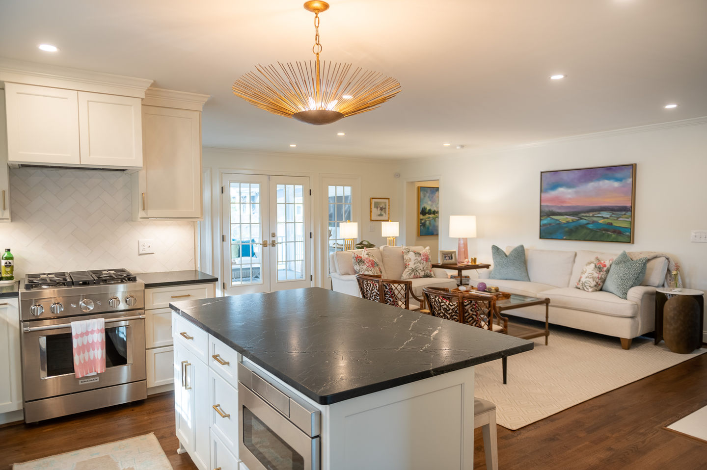 a kitchen with white cabinets and a black counter top