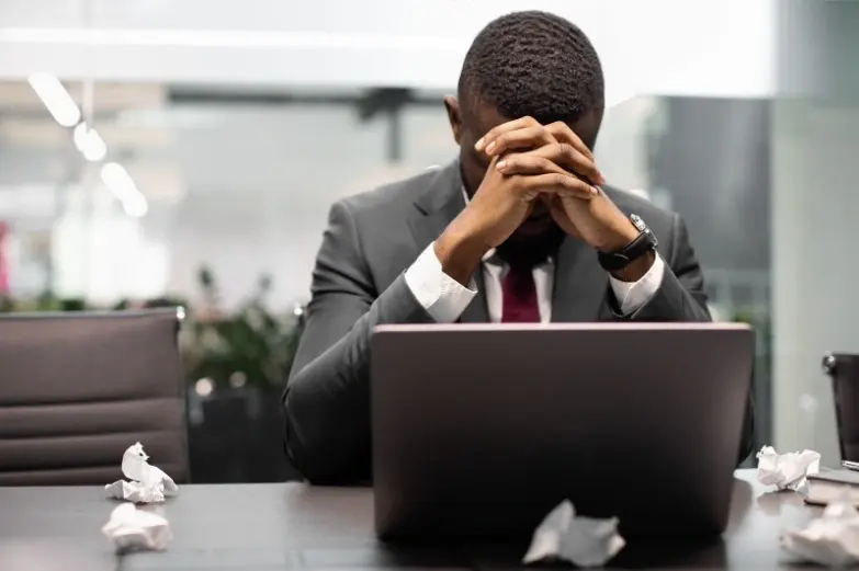 Homem com a cabeça baixa em frente ao computados