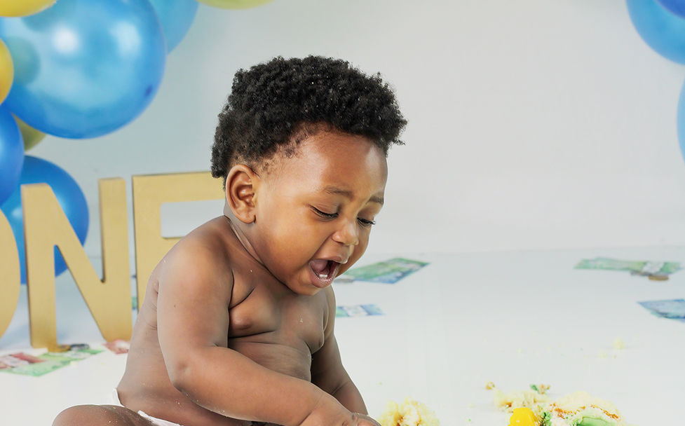 Baby boy smashing cake with blue and gold set up