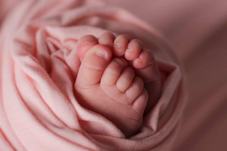 Newborn baby toes wrapped in pink