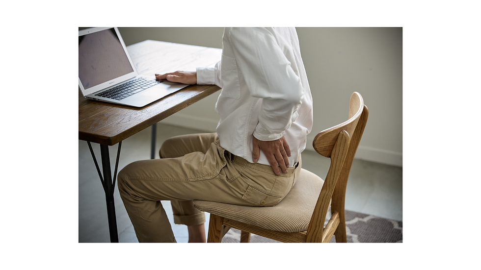 'Office worker holding lower back in pain at desk — lower back pain treatment at Well By Design Chiropractic Balwyn North'