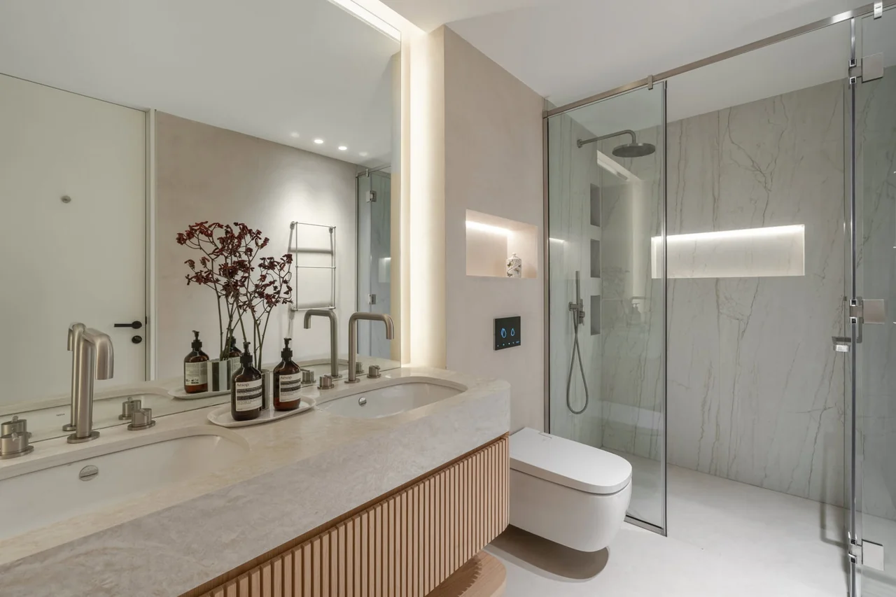 Montenegro apartment bathroom with a long pale vanity, timber drawers and a glazed shower.