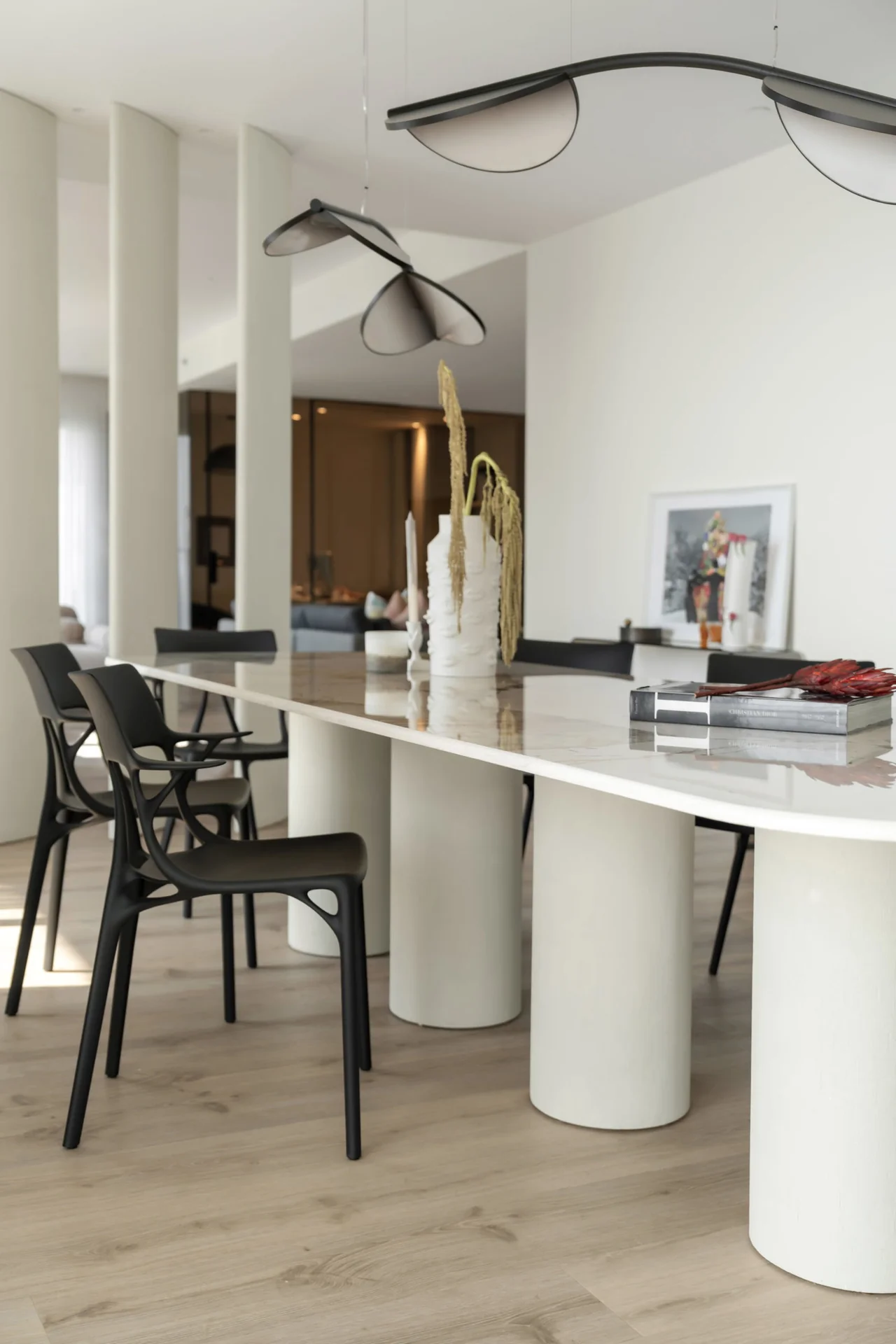 Sculptural dining lighting and pale stone furniture in the Montenegro beachfront apartment.