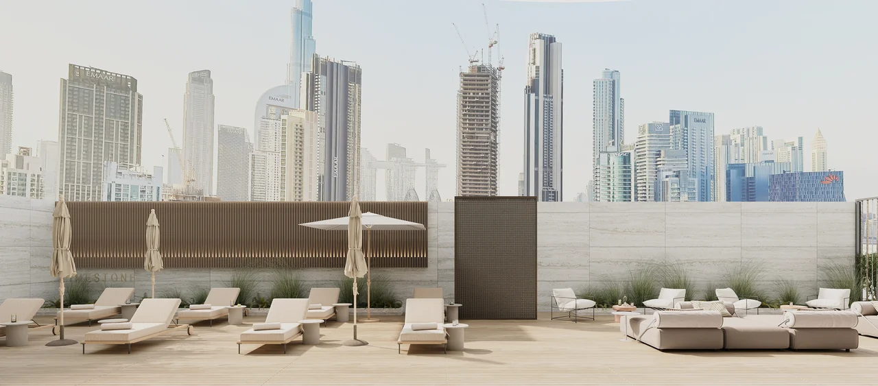 Limestone outdoor leisure deck design with loungers, parasols and the Dubai skyline beyond.