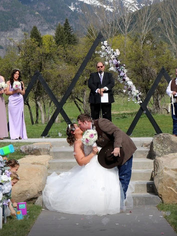 Bride and groom kiss at an outdoor mountain wedding.