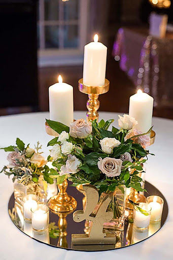 Fresh florals with pillar candles on gold stands