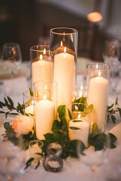 Mixed cylinder vases pillar candles and fresh foliage