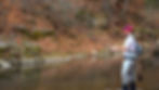 Fly fisherman practicing casting in a stream in late fall