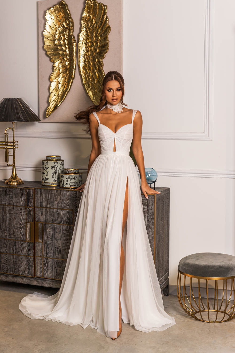 Model in white flowing dress with high leg slit