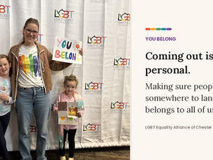 A woman in a "Love Wins" rainbow T-shirt stands with two young girls in front of an LGBT Equality Alliance of Chester County backdrop, beside a balloon arch. One girl holds a handmade sign reading "Love Happy Lucy"; the woman holds one reading "You Belong." Text beside the photo reads: "Coming out is personal. Making sure people have somewhere to land belongs to all of us."