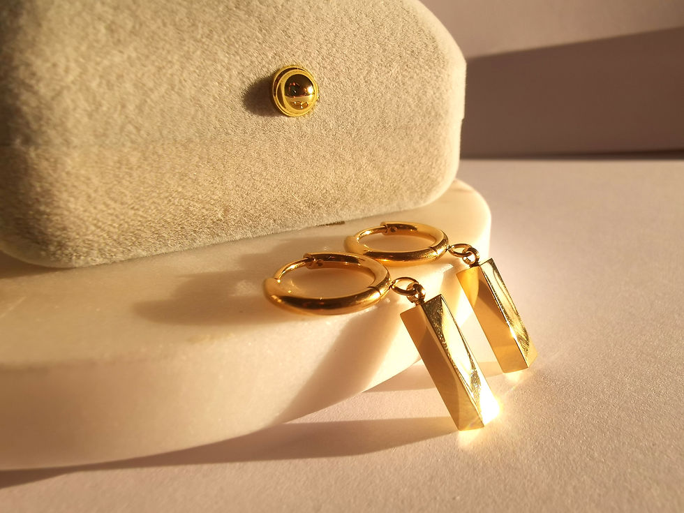 Gold hoop earrings with rectangular bar pendants, featuring a polished minimalist design on a soft neutral background.