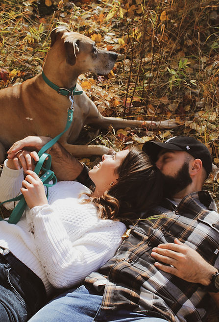 Couples photoshoot. Loving couple laying next to their beloved dog