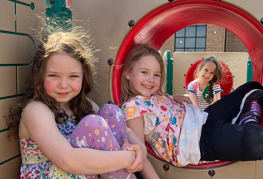 Happy preschool girls playing on playground