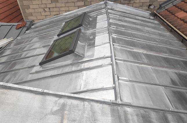 Notre équipe de couvreurs zingueur expérimentés, dirigée par Hornec, garantit des travaux de qualité pour tous vos projets de couverture en zinc, tels que le remplacement de couverture, la réfection de rive, de noue en zinc, la pose de gouttières, l'installation de fenêtre de toit, le remplacement de descente d'eau pluviale et la réfection de solins de cheminée.