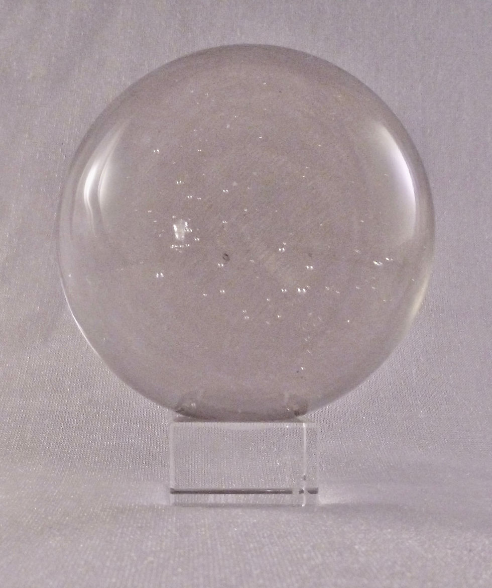 Eine klare Kristallkugel auf einem transparenten Sockel zur Schau gestellt.