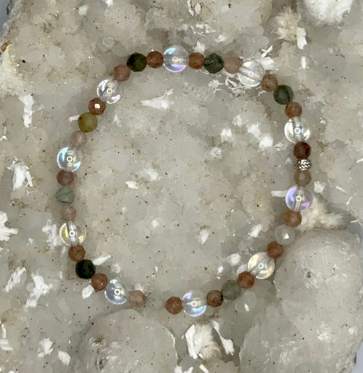 Armband aus bunten Edelsteinen liegt auf einem weißen Untergrund. Amaris.