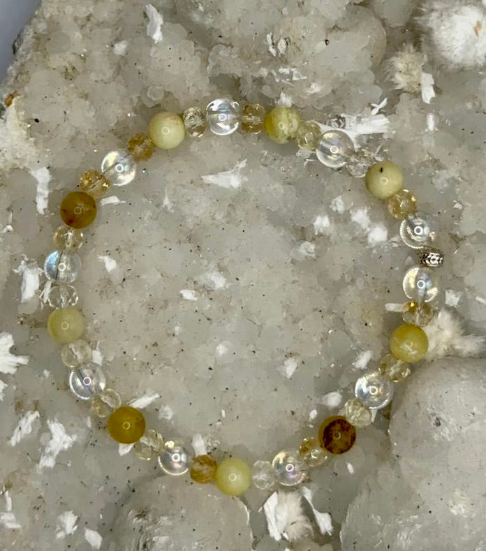 Gelbes Armband mit Kristallen. Schmuckstück auf einer weißen Oberfläche. Amaris.